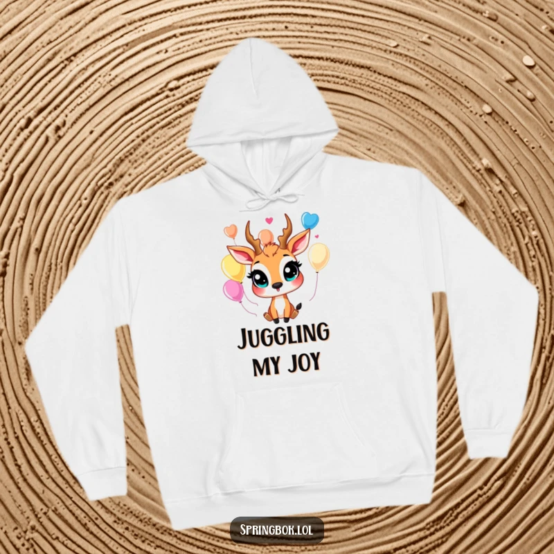 Funny springbok hoodie depicting a happy springbok with large eyes, humorously juggling bright, colorful balloons for maximum fun.