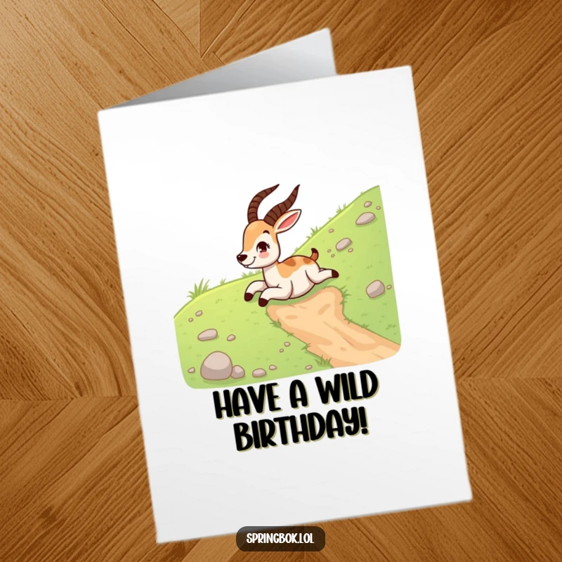 Funny Free Printable Birthday Card: Springbok gleefully sliding down a grassy hill on its belly, pure birthday fun. Downloadable.